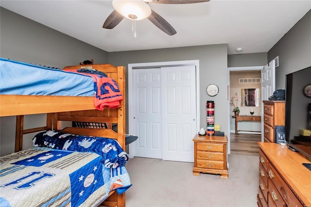 carpeted bedroom with visible vents, a closet, and ceiling fan