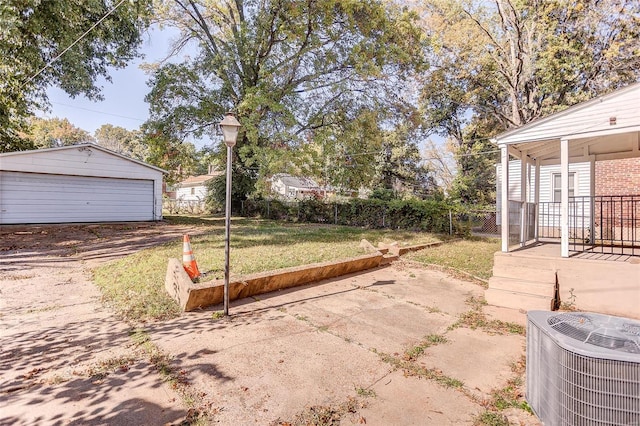 view of yard featuring a garage, central AC, an outdoor structure, and fence