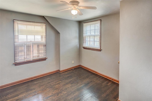 spare room featuring ceiling fan, baseboards, and dark wood finished floors