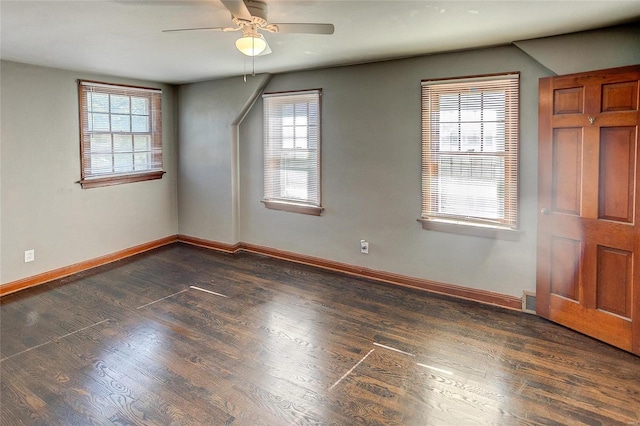 spare room with plenty of natural light, baseboards, ceiling fan, and dark wood-style flooring