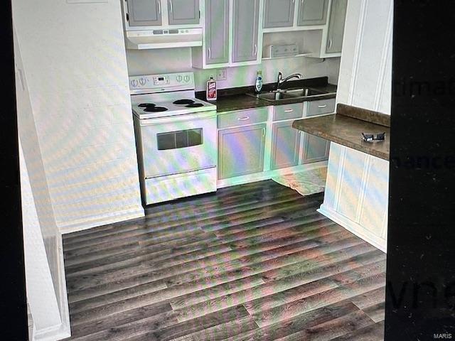 kitchen with gray cabinetry, sink, white electric range oven, dark wood-type flooring, and exhaust hood