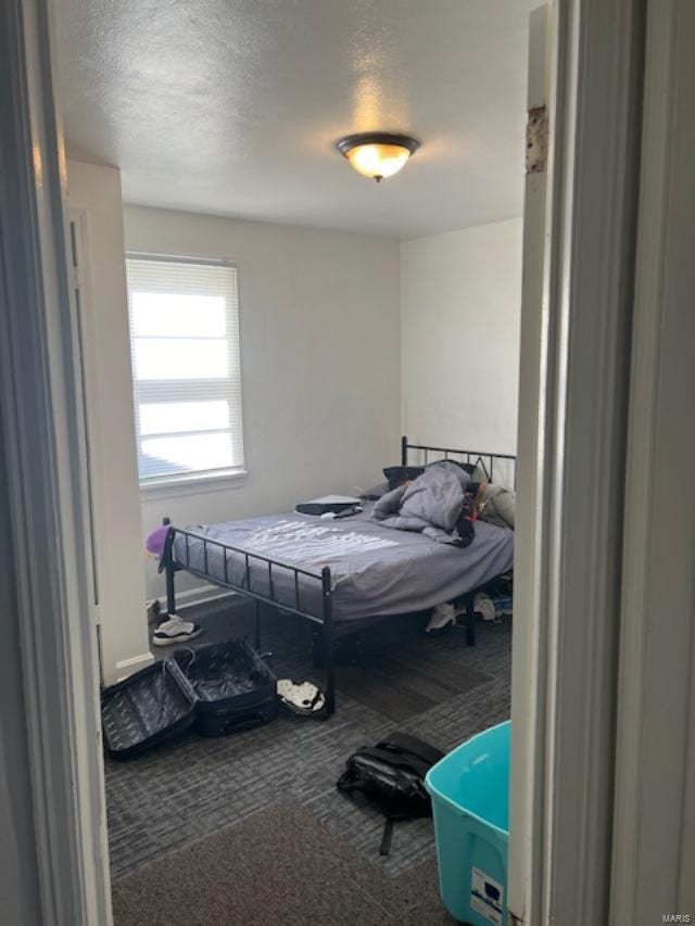 carpeted bedroom featuring a textured ceiling