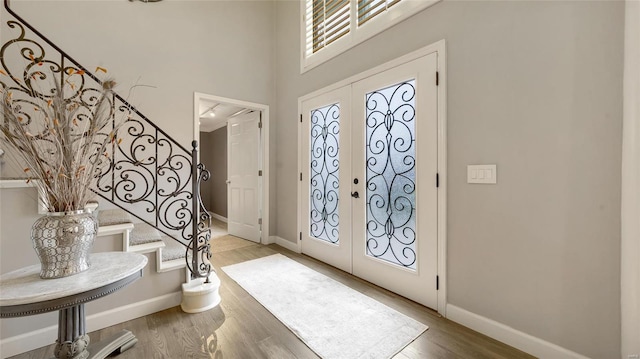 entryway featuring french doors, a high ceiling, and hardwood / wood-style floors