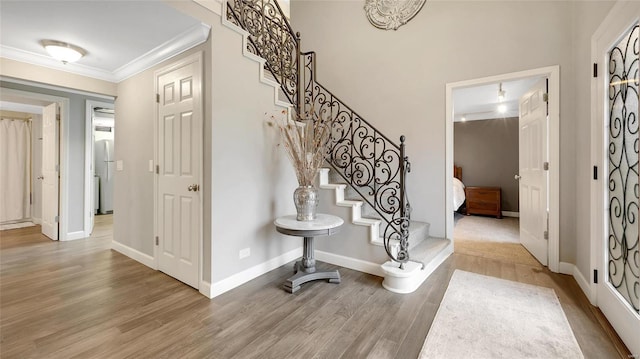 entrance foyer with hardwood / wood-style floors and ornamental molding