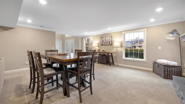 dining space with light colored carpet and ornamental molding