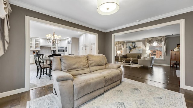 living room featuring a notable chandelier, wood-type flooring, and crown molding