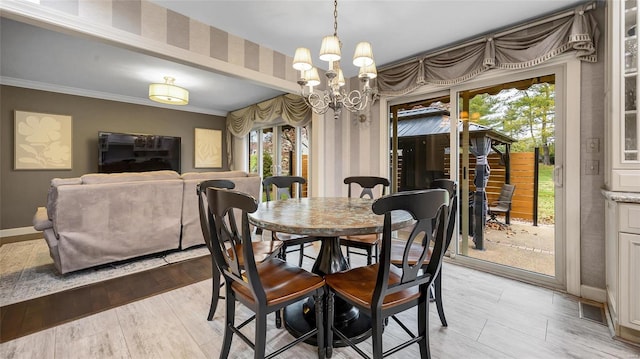 dining room featuring light hardwood / wood-style floors, an inviting chandelier, and crown molding