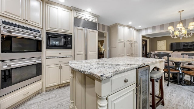 kitchen featuring stainless steel double oven, black microwave, beverage cooler, pendant lighting, and a chandelier