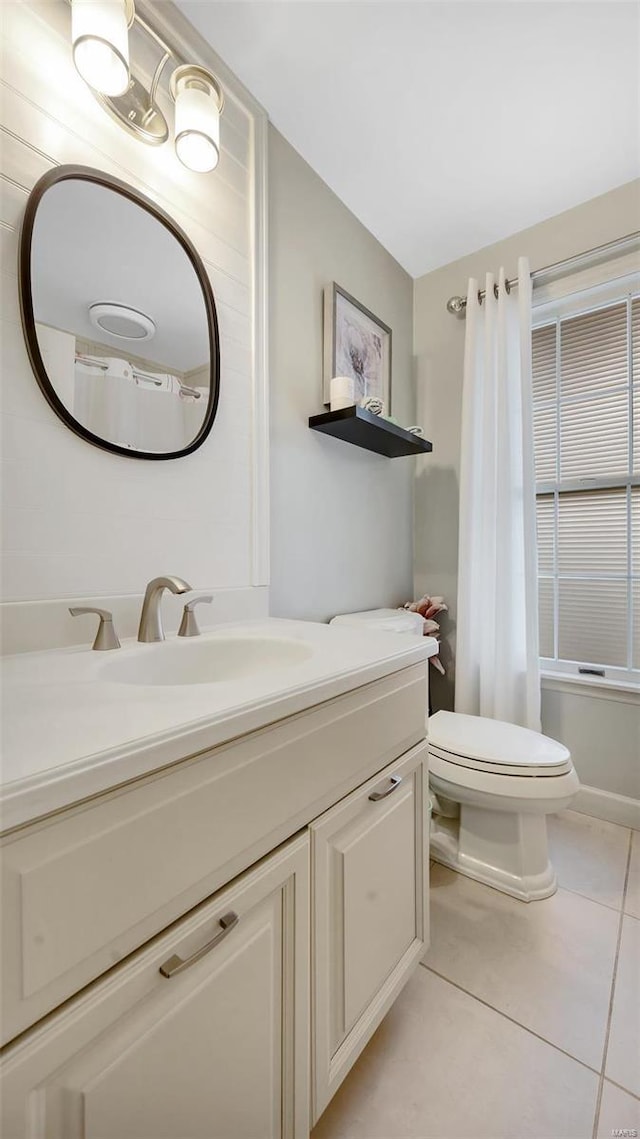 full bathroom featuring toilet, vanity, tile patterned floors, and shower / tub combo with curtain