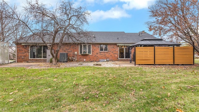 back of property with central AC, a yard, and a patio