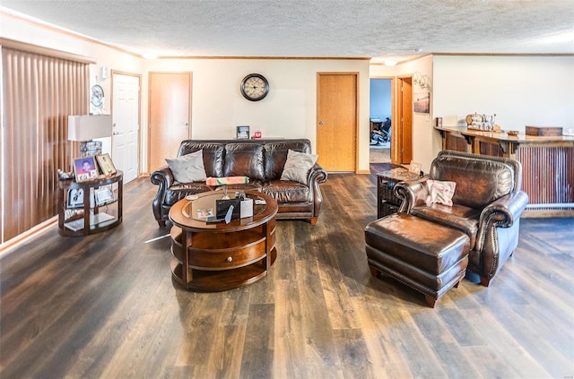 living room featuring dark hardwood / wood-style floors, a textured ceiling, and ornamental molding