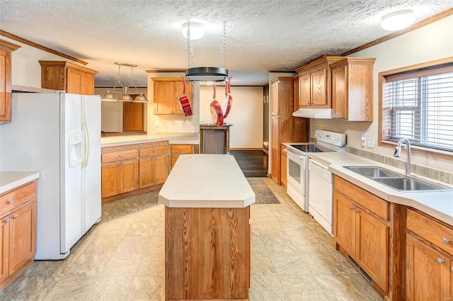 kitchen featuring ornamental molding, white appliances, sink, pendant lighting, and a kitchen island