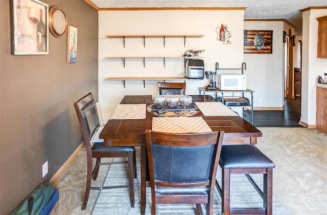 dining room featuring carpet, crown molding, and a textured ceiling