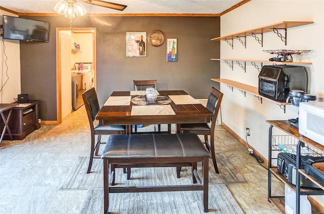 dining room with ceiling fan, washing machine and dryer, and crown molding