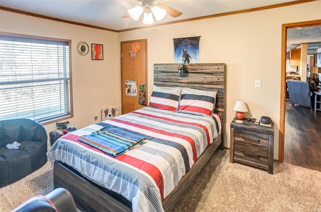 carpeted bedroom featuring ceiling fan and ornamental molding