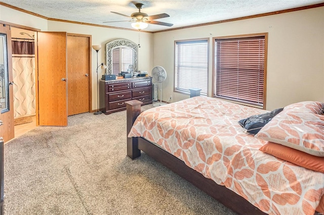 bedroom with ceiling fan, light colored carpet, ornamental molding, and a textured ceiling