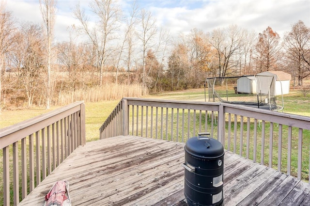 deck featuring a grill, a storage shed, and a yard