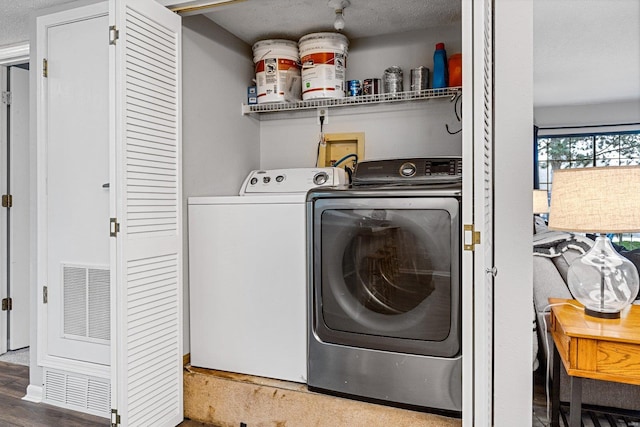 laundry area with washer and clothes dryer, dark hardwood / wood-style floors, and a textured ceiling