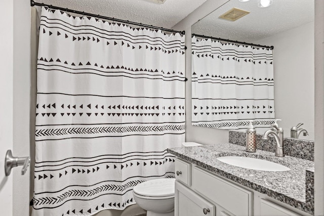 bathroom with vanity, a textured ceiling, and toilet