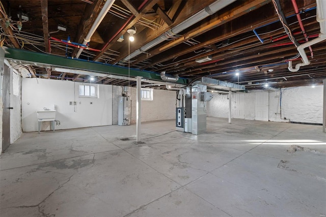 basement with heating unit, sink, and water heater