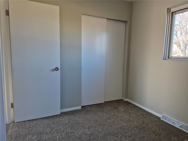 unfurnished bedroom featuring carpet flooring and a closet