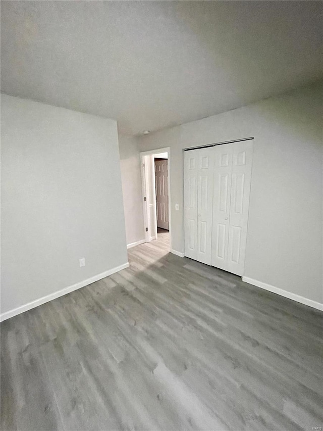 unfurnished bedroom featuring wood-type flooring and a closet