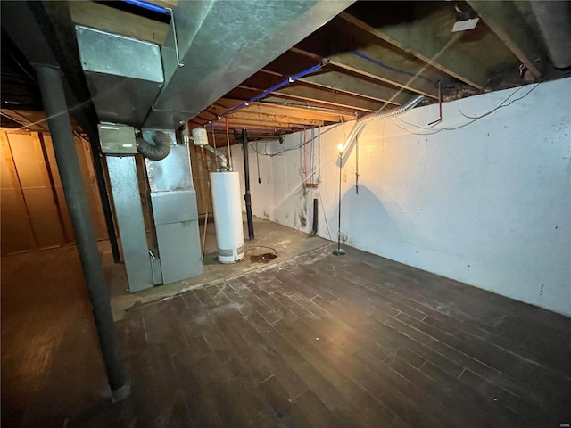 basement featuring dark hardwood / wood-style floors and gas water heater