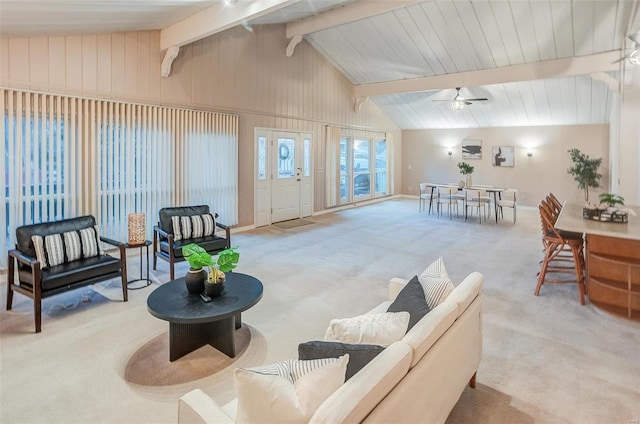 carpeted living room with vaulted ceiling with beams and ceiling fan