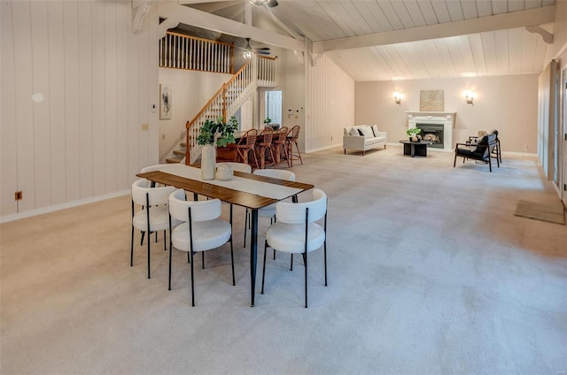 dining space with vaulted ceiling with beams, light colored carpet, and ceiling fan