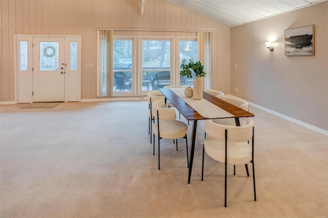 dining room featuring light carpet and vaulted ceiling