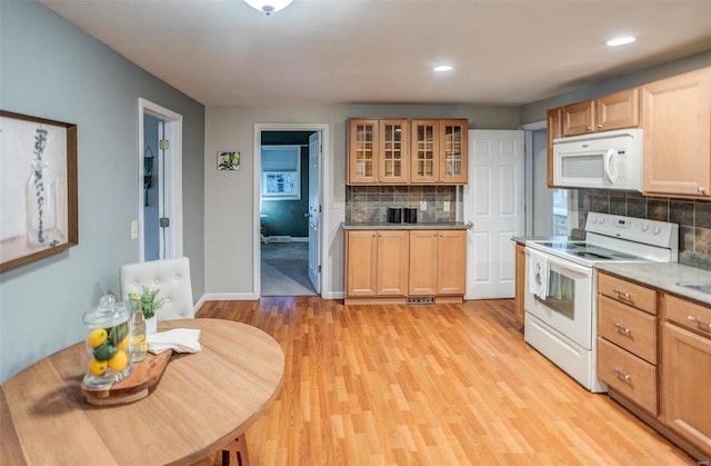 kitchen featuring backsplash, light brown cabinetry, light hardwood / wood-style floors, and white appliances