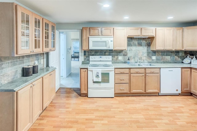 kitchen featuring sink, light wood-type flooring, white appliances, and light brown cabinets