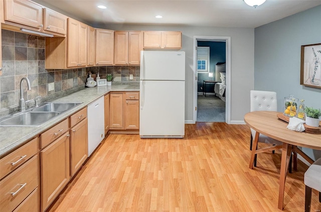 kitchen featuring white appliances, sink, light brown cabinetry, and light hardwood / wood-style flooring