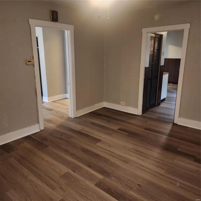 empty room with dark hardwood / wood-style flooring