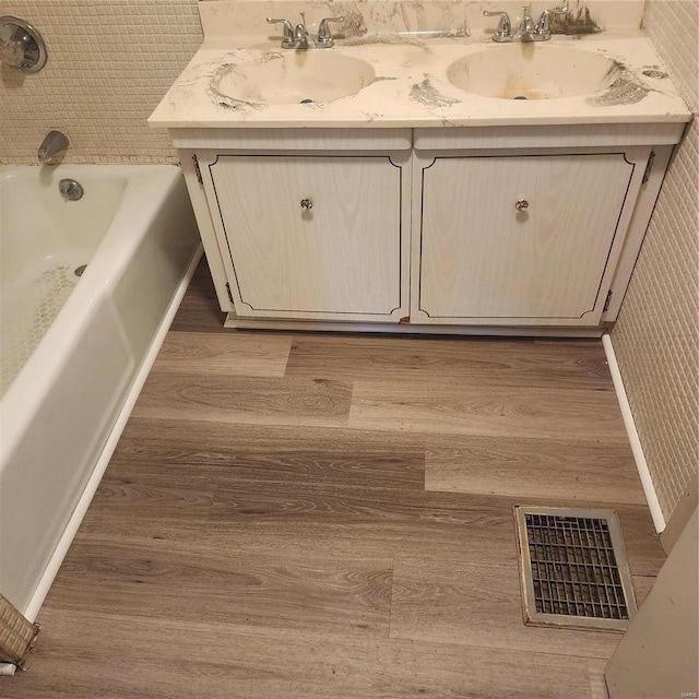 bathroom featuring a tub to relax in, vanity, and hardwood / wood-style flooring