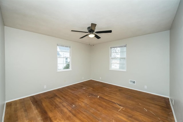 spare room featuring ceiling fan, dark hardwood / wood-style flooring, and a wealth of natural light