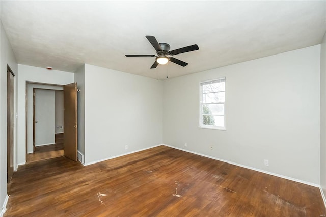 spare room with ceiling fan and dark hardwood / wood-style flooring