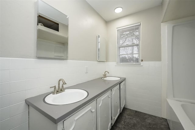 bathroom featuring vanity, a bathtub, and tile walls