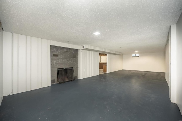 basement with a fireplace and a textured ceiling