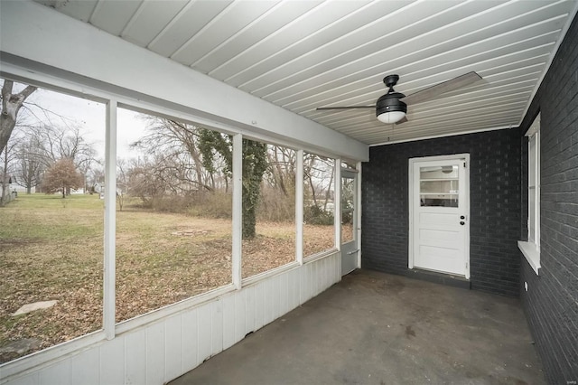 unfurnished sunroom featuring ceiling fan