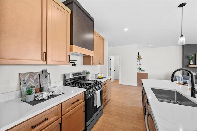 kitchen featuring sink, stainless steel gas range oven, light hardwood / wood-style flooring, decorative light fixtures, and dishwashing machine