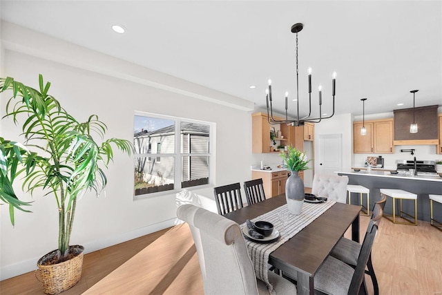 dining space featuring light hardwood / wood-style flooring and a notable chandelier