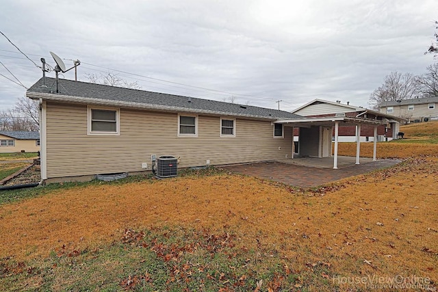 rear view of property featuring a lawn, a patio, and central AC unit