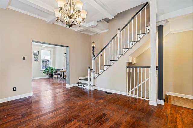 foyer entrance with an inviting chandelier, coffered ceiling, dark hardwood / wood-style floors, crown molding, and beam ceiling