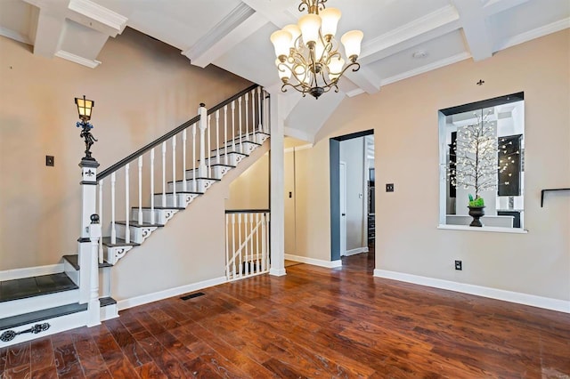 entryway featuring dark wood-type flooring, ornamental molding, an inviting chandelier, and beamed ceiling