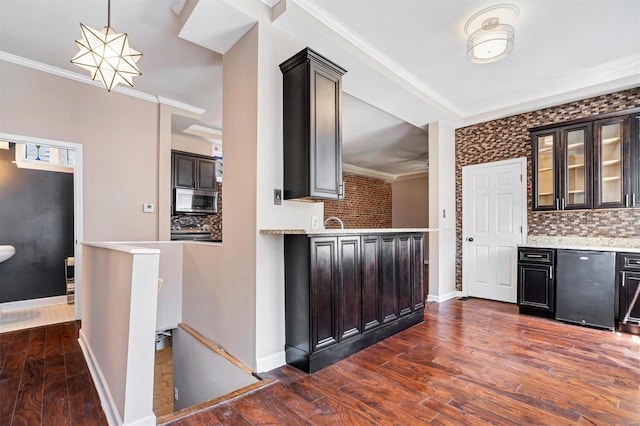 kitchen with hanging light fixtures, appliances with stainless steel finishes, brick wall, and tasteful backsplash