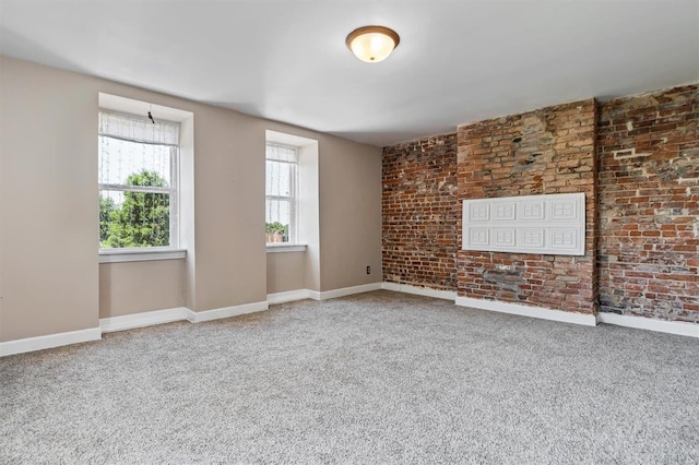 carpeted empty room with brick wall