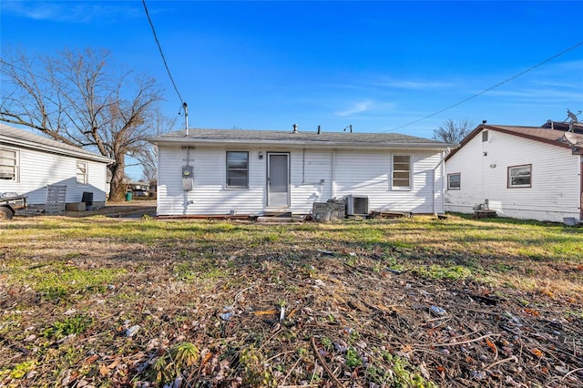 rear view of house with a yard and central AC