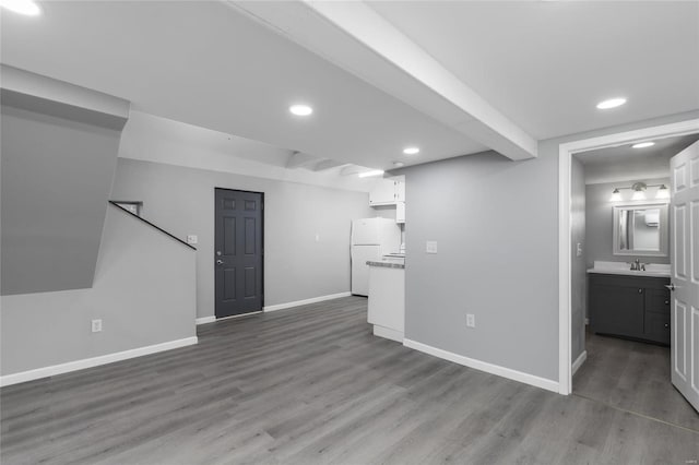 unfurnished living room featuring hardwood / wood-style flooring and sink