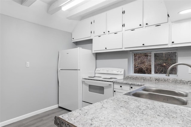 kitchen with white appliances, sink, vaulted ceiling, hardwood / wood-style flooring, and white cabinetry